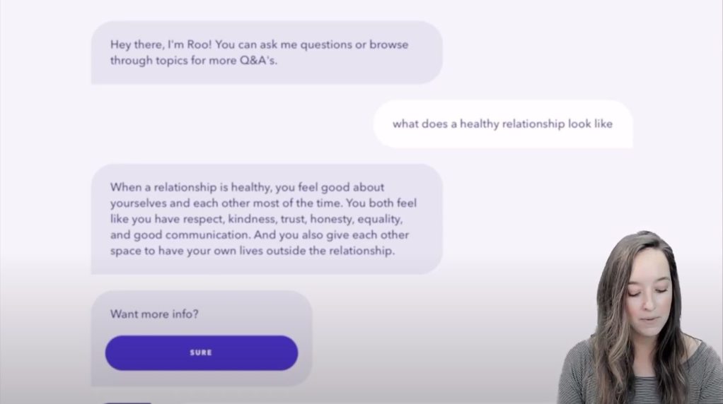 A woman speaking with a virtual background of a chatbot.