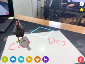A virtual chicken standing on a sheet of paper.